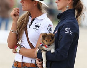 Belgian FEI rider Larissa Pauluis is coaching a French rider, French chef d'equipe Alizee Froment watches. Her puppy has a French ribbon round his neck.