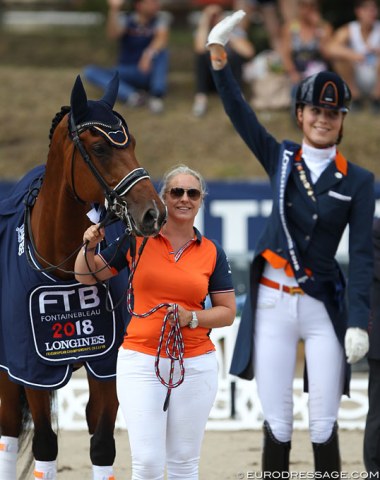 Proud mom Helga van Peperstraten holds Cupido as her daughter stands on the highest step of the podium
