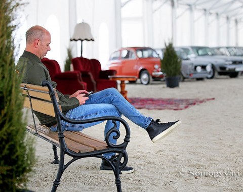 Hans Peter Minderhoud taking a break with the classic car show in the background
