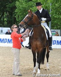 Isabell Werth helps her assistant trainer Matthias Bouten on Flatley