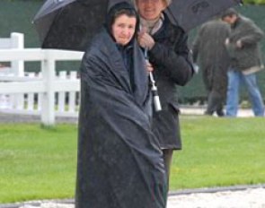 Werth's sponsor Madeleine Winter-Schulze and groom Anna Kleniuk sheltering from the pouring rain.