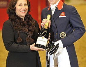 Lisa Wells, representative for Reem Acra, presents Laura Bechtolsheimer with her winner's rosette and a bottle of champagne