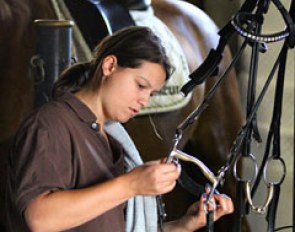 Groom Ninon Meunier taking care of the tack