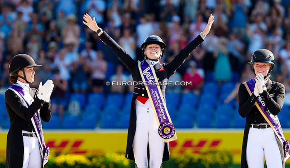 Charlotte Fry wins Grand Prix Special gold at the 2026 World Championships. Joined on the podium by Dufour and Hemmer :: Photo © Astrid Appels