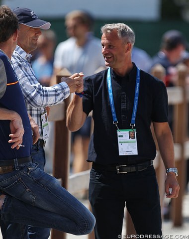 Blue Hors trainer Lars Petersen and sport director Ulrik Sorensen high five with fists over Bachmann's 82.195%