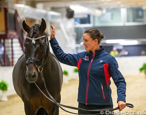 Adrienne Lyle gives Betsy Juliano's 12-year old Hanoverian stallion Salvino (by Sandro Hit x Donnerhall) a pat 