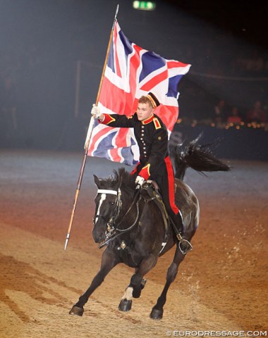 All four feet off the ground: Mounted horse guard waves the union jack