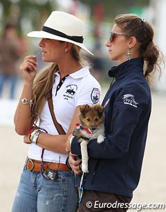 Belgian FEI rider Larissa Pauluis is coaching a French rider, French chef d'equipe Alizee Froment watches. Her puppy has a French ribbon round his neck.