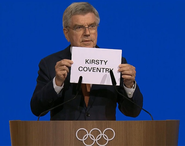 IOC president Thomas Bach shows the name of the winner of the secret ballot at the 144th IOC Session being held in Costa Navarino