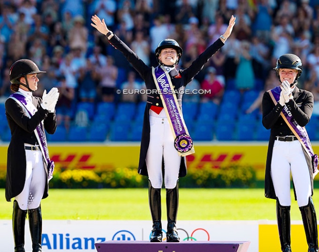Charlotte Fry wins Grand Prix Special gold at the 2026 World Championships. Joined on the podium by Dufour and Hemmer :: Photo © Astrid Appels