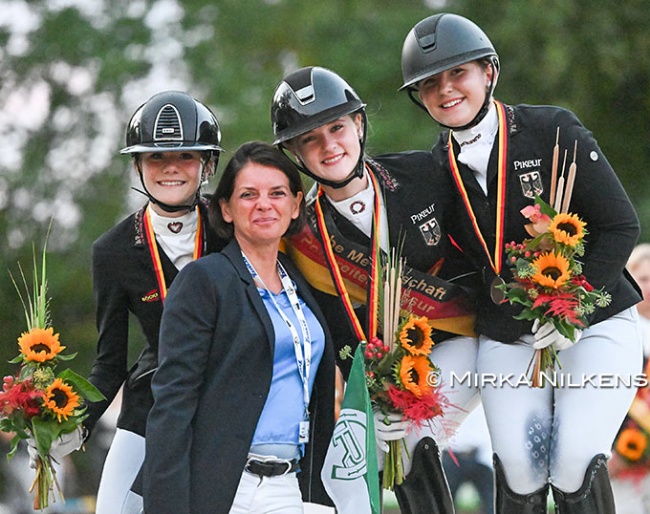 The pony podium at the 2026 German Youth Riders Championships with Kasselmann, Gosmann, and von Helldorff. Team trainer Caro Roost in front :: Photo © Mirka Nilkens